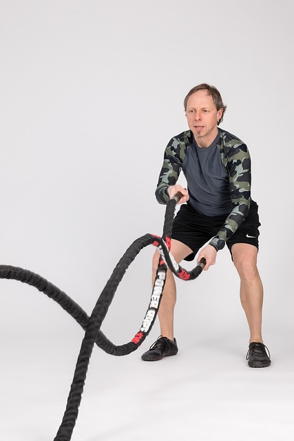 Focused athlete performing battle ropes, emphasizing high-intensity conditioning.